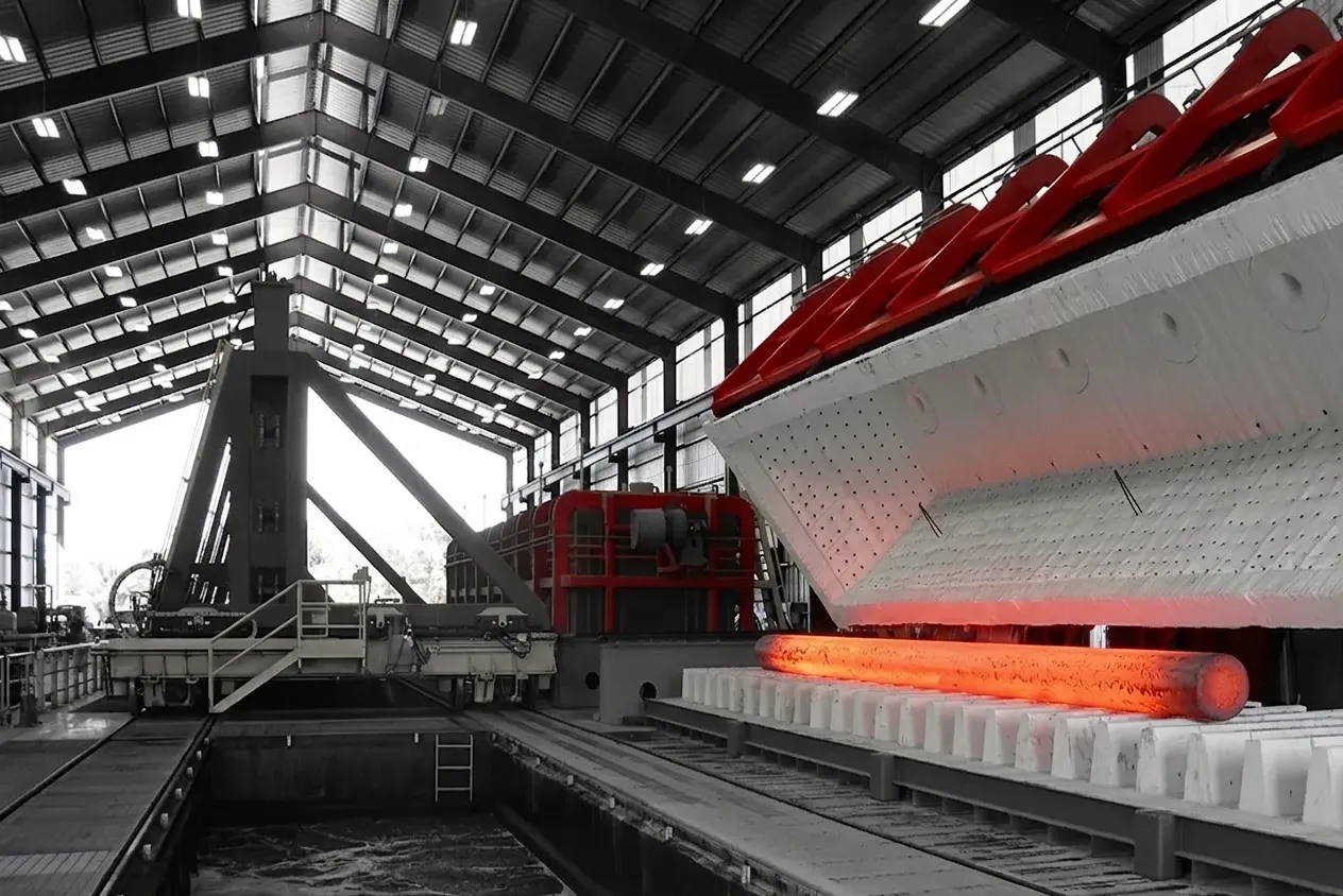Industrial heat treating furnace with glowing red-hot steel